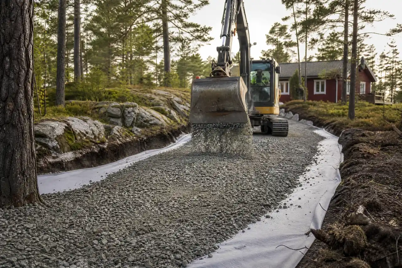 Nyanlagd grusväg med jämn grusyta genom skogsmark